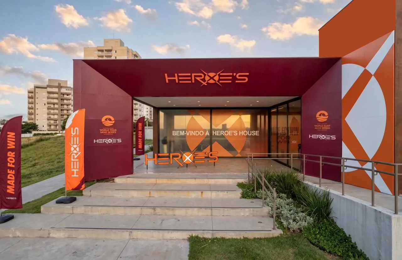 Entrada principal com pórtico vermelho e a chamada da marca aplicada na parede