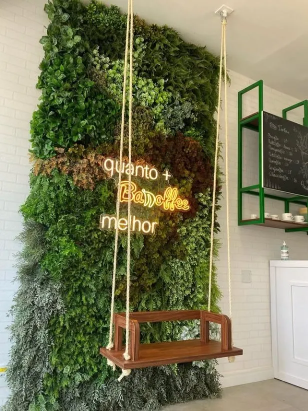 Foto da obra entregue: jardim vertical com balanço de madeira e neon "quanto + Banoffee melhor"